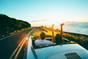Happy-Couple-Driving-into-the-Sunset-to-top-luxury-wellness-retreats-in-California