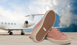 dust-pink-lazy-luxury-sneakers-on-tarmac-with-a-jet