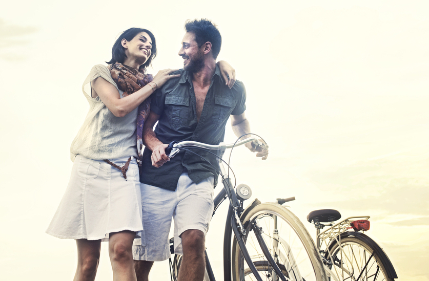 happy couple with bike living in one of the top countries for finding happiness