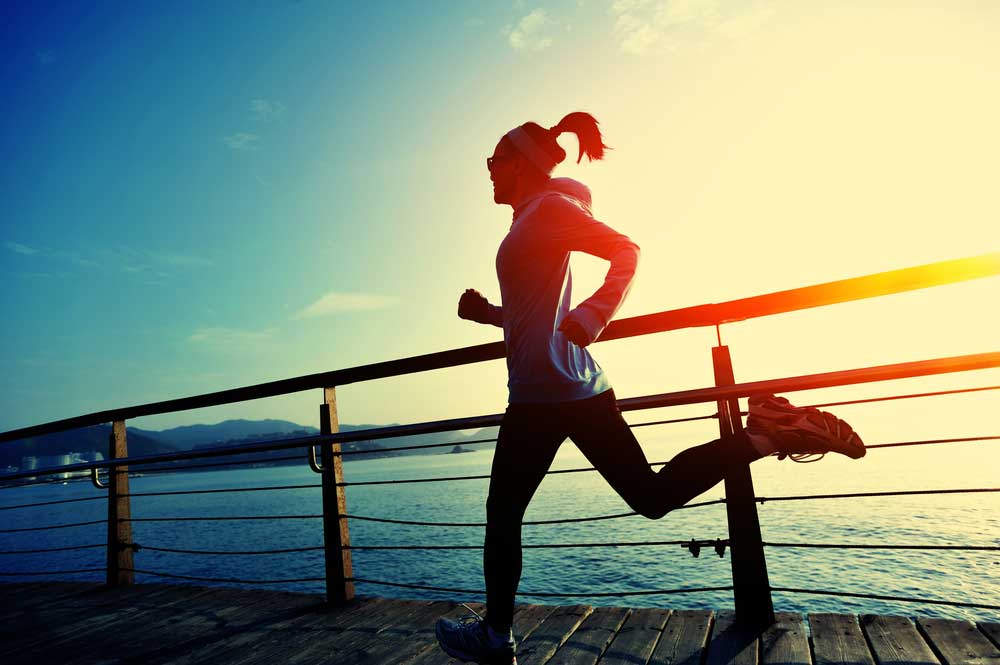 healthy-lifestyle-sports-woman-running-on-wooden-boardwalk-sunrise-seaside