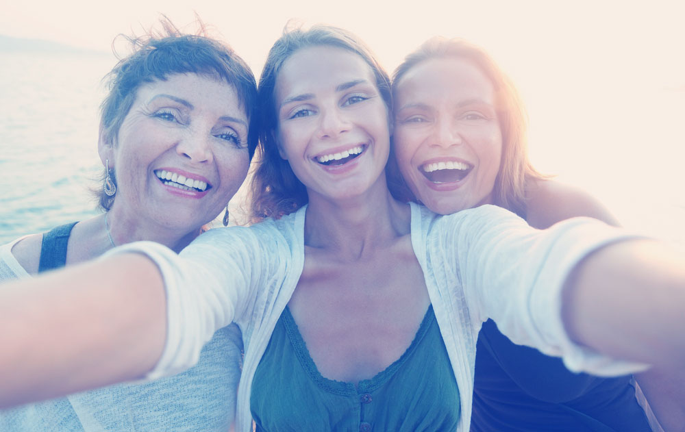 mother-and-two-adult-daughters-are-doing-Selfie-on-the-beach