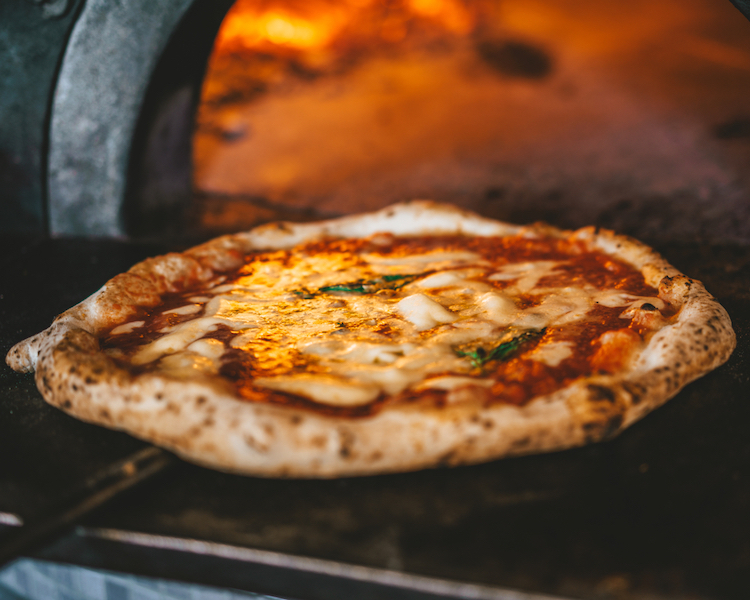 pizza by a wood-burning oven