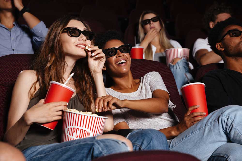 women-enjoying-popcorn-in-a-theater